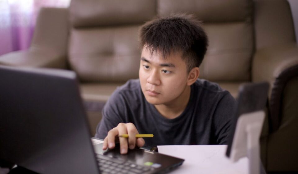 Young adult concentrates on laptop screen