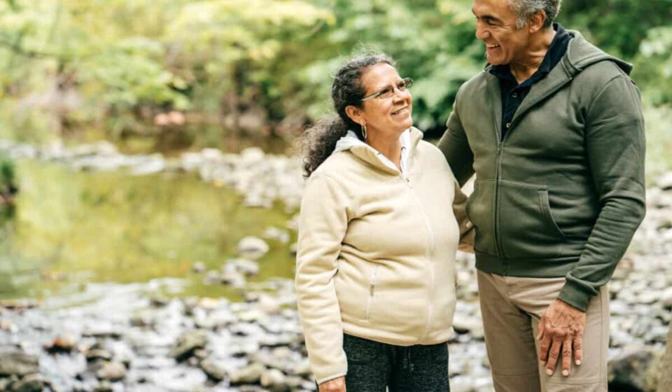 Two seniors walk in the forest