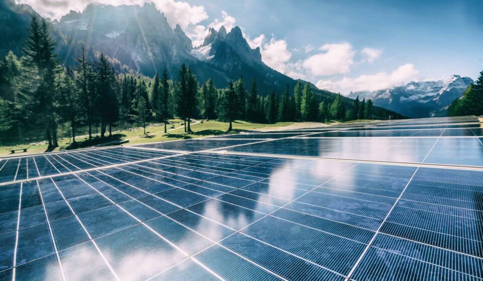 A solar cell panel generates power in a country mountain landscape.