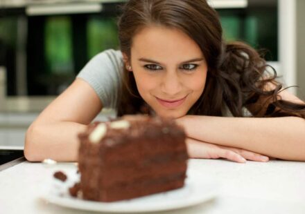 woman stares at chocolate layer cake