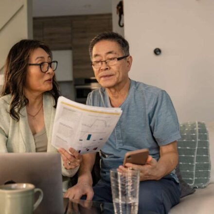 senior couple looks at investing statements