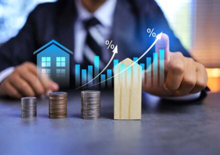 Real estate investment concept with person pointing on growth graph and coin stacking to get profit from property